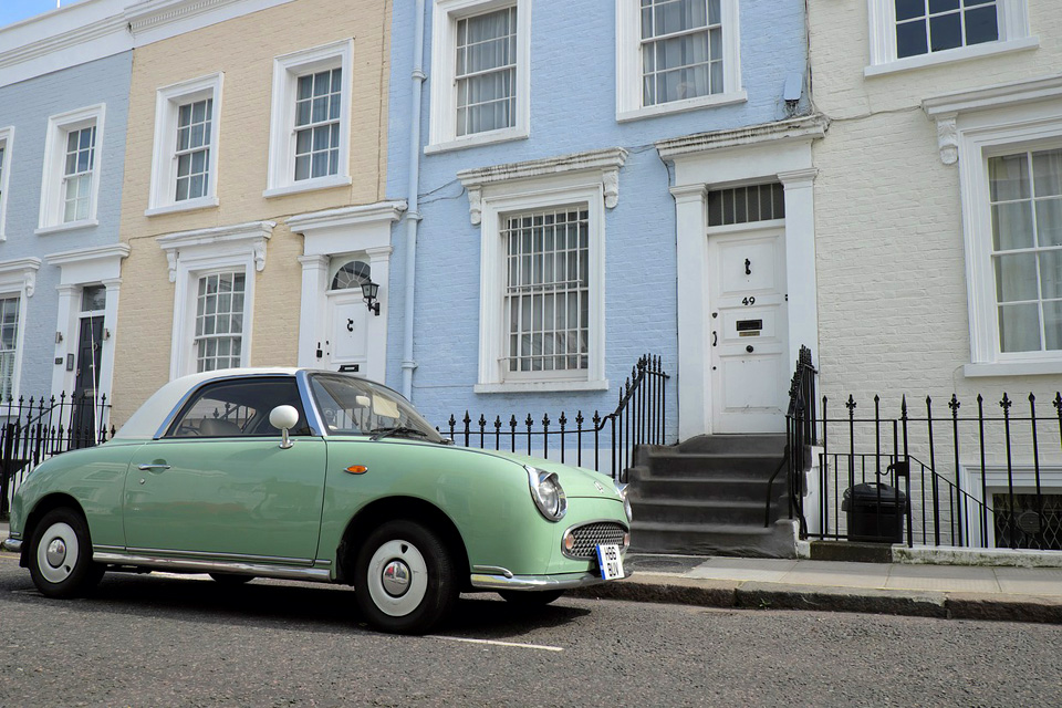 An old mint coloured car, outside colourful old Victorian buildings in Portobello Road.